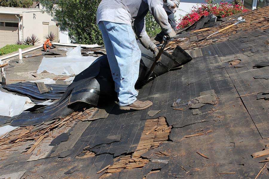 roofer inspecting damaged roof