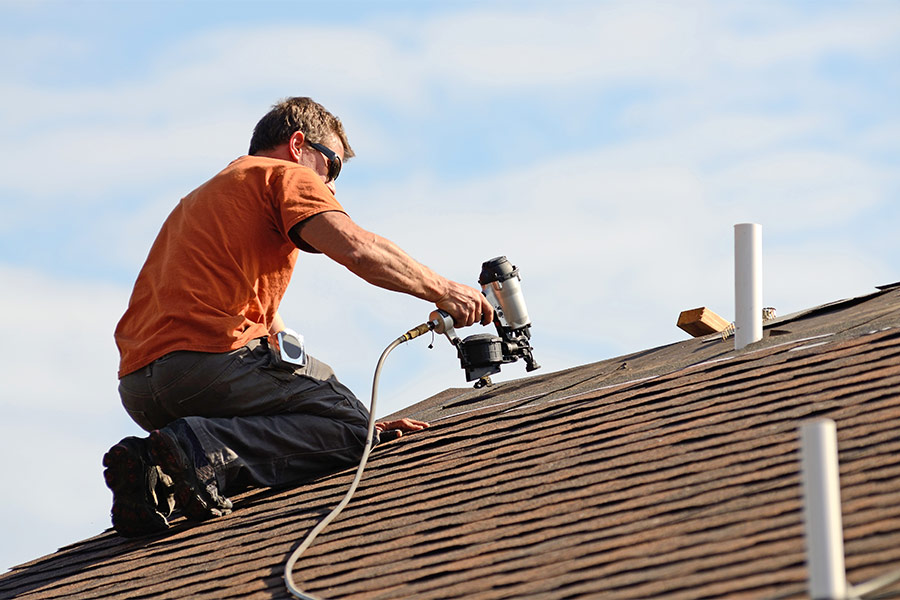 roofer with nail gun installing roofjpg