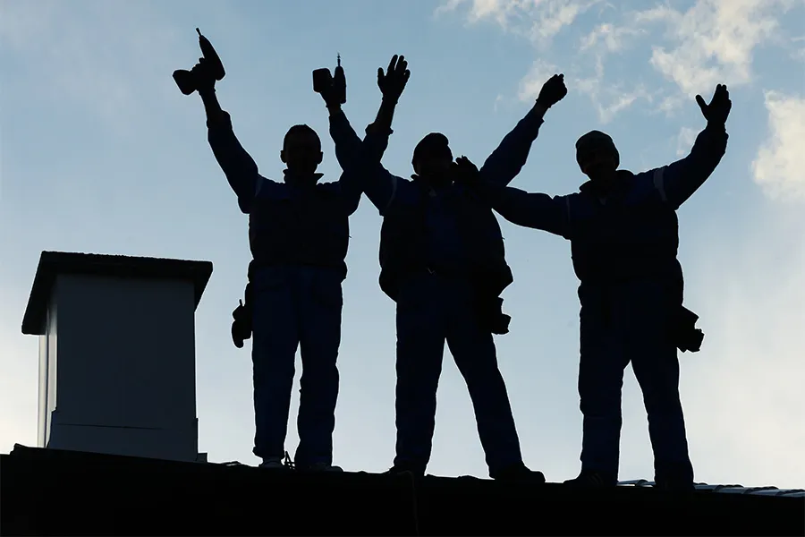 group of roofers standing on roof